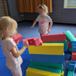 Zwei Mädchen spielen mit Schaumstoffblöcken in der Turnhalle