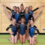 Acht Mädchen posieren symmetrisch als Gruppe.