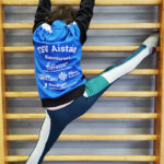 Ein Mädchen turnt an einer Sprossenwand.