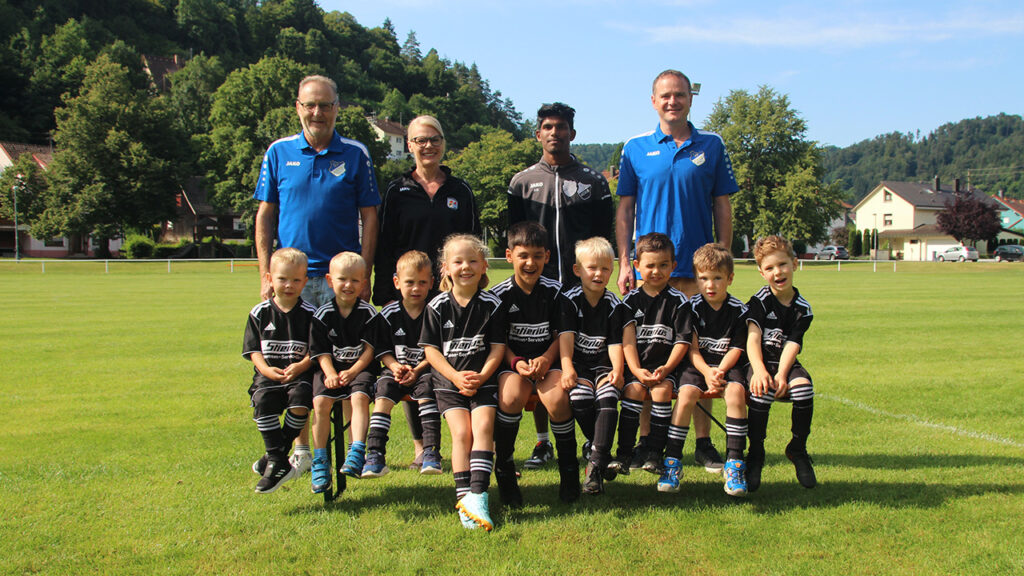 Spieler und Trainer der Bambinis stehen versammelt auf dem Spielfeld.