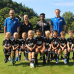 Spieler und Trainer der Bambinis stehen versammelt auf dem Spielfeld.