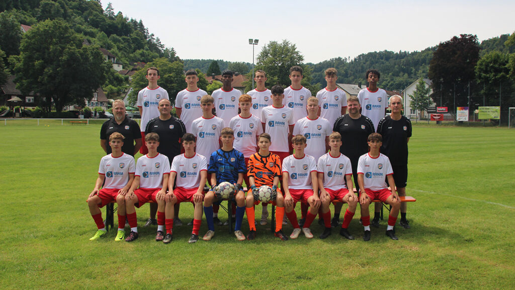 Spieler und Trainer der A-Jugend stehen versammelt auf dem Spielfeld.