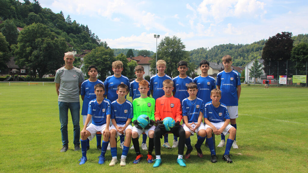 Spieler und Trainer der C-Jugend stehen versammelt auf dem Spielfeld.