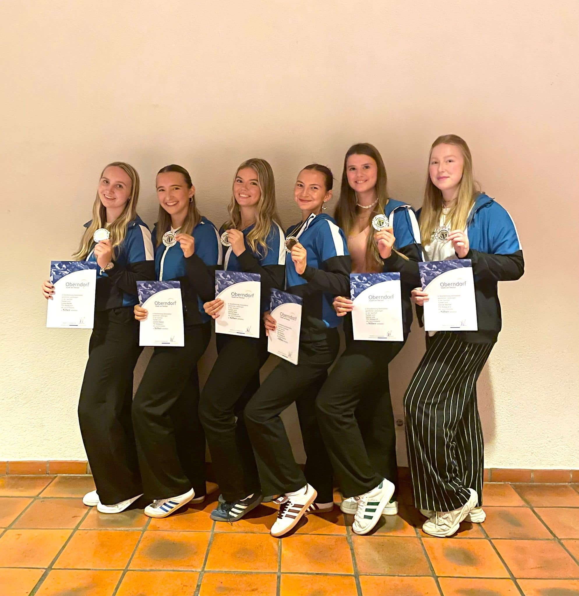 Hannah Blocher, Lysiane Wagner, Samira Link, Lilly Lehman, Lorena Bantle, Lorena Radu, Eva Mauch und Mia Vollmer halten Urkunden und Silber-Medaillien in den Händen.