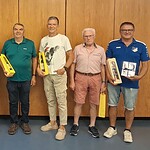 Sieben Mitglieder des TSV Aistaig stehen vor einer Wand. Einige von ihnen halten Präsente.
